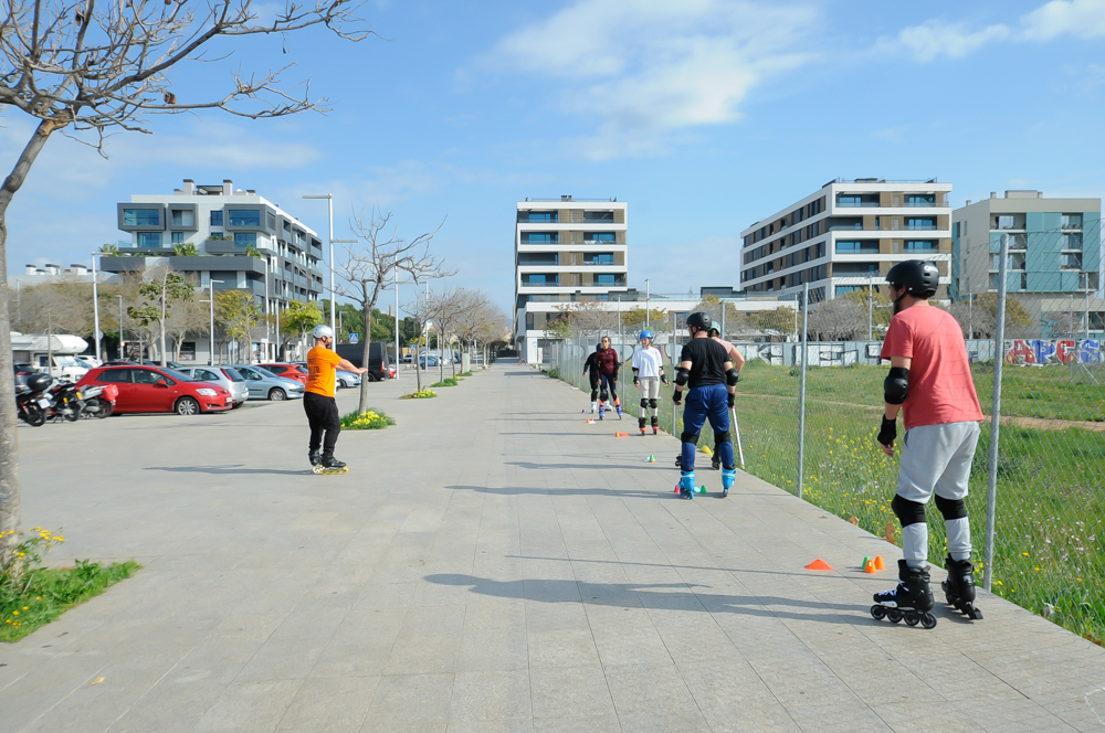 Adultos realizando un ejercicio de equilibrio en la pista de patinaje